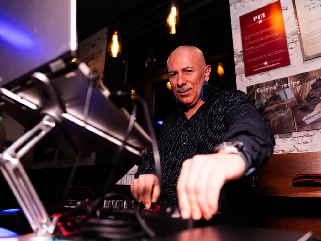 DJ Alex Bedeleu mixing at club event with blue and pink lights